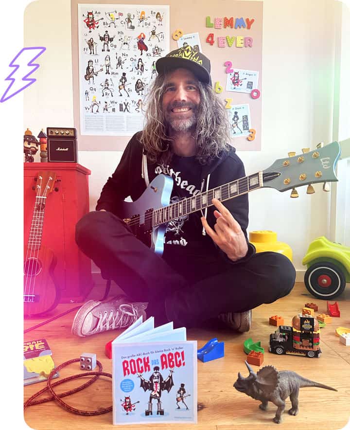 Der Gründer von Little Big Rocker sitzt inmitten seiner Produkte in einem Kinderzimmer.